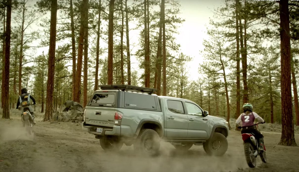 pick-up in a forest with two motorcycles