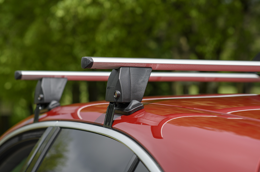 two grey roof racks clamped to a red vehicle in the forest 
