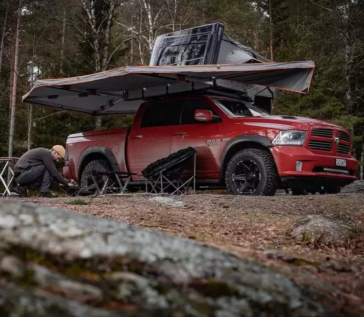 Red Dodge Ram with roof tent and gray Awning