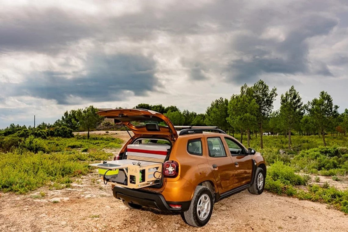 Orange Dacia Duster parked in the wild with a box fitted inside
