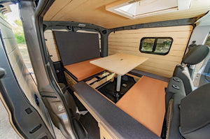 interior of a van with wooden furnishings, a table and a cabinet