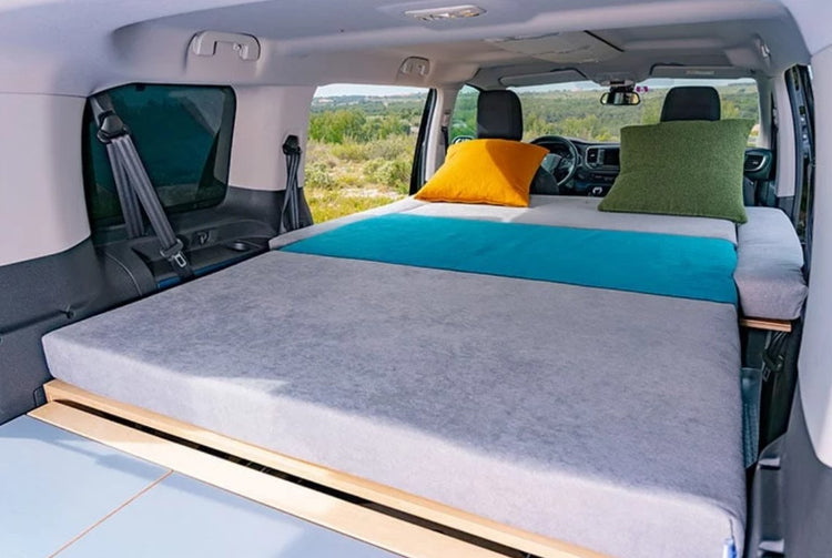 grey and blue mattress in a van with open doors