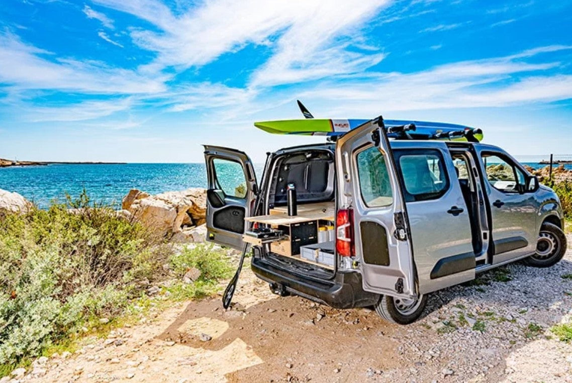 A converted van in front of the sea