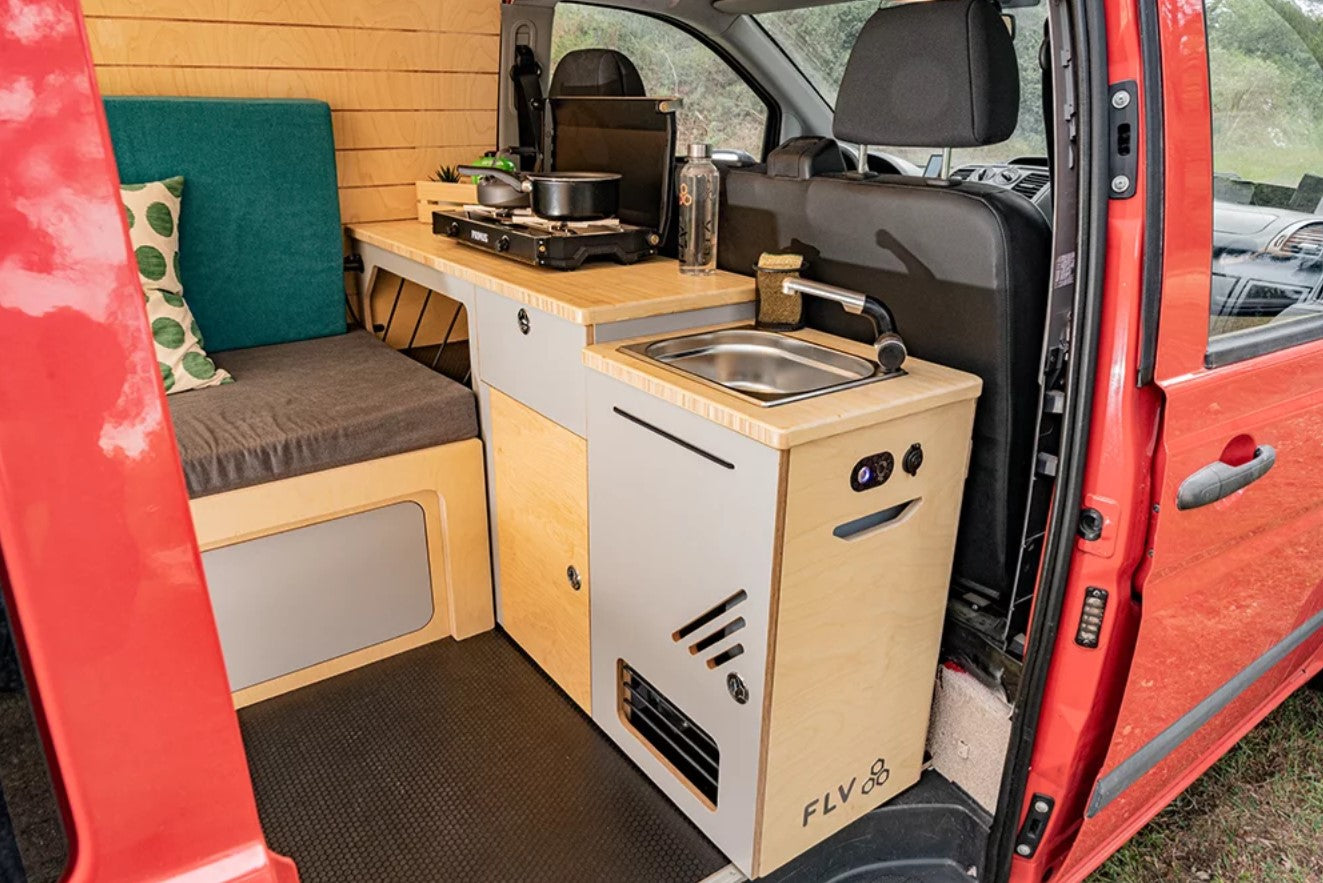 Interior of a converted van with kitchen and sink module