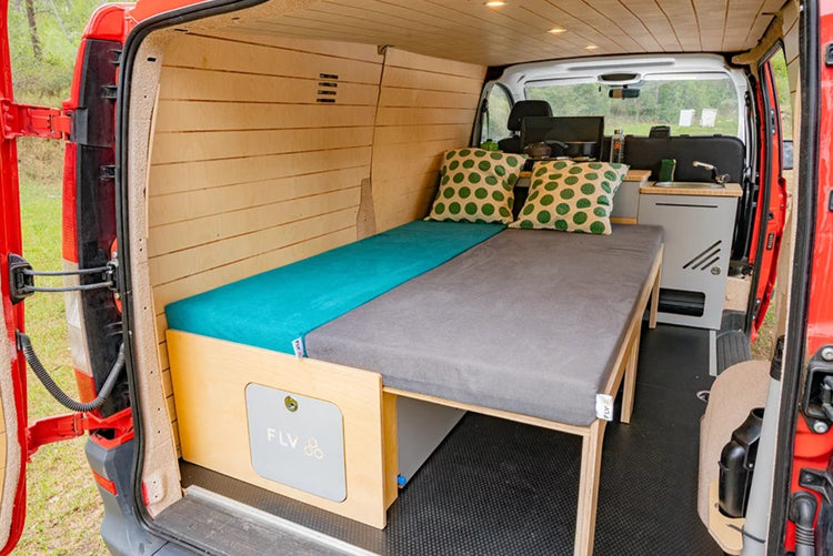 wood-furnished modulus in a red van with the bed unfolded