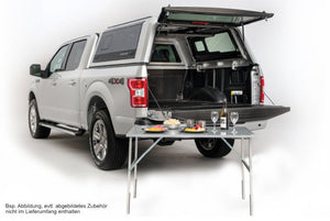 gray pickup equipped with a Canopy Hardtop and a table in front