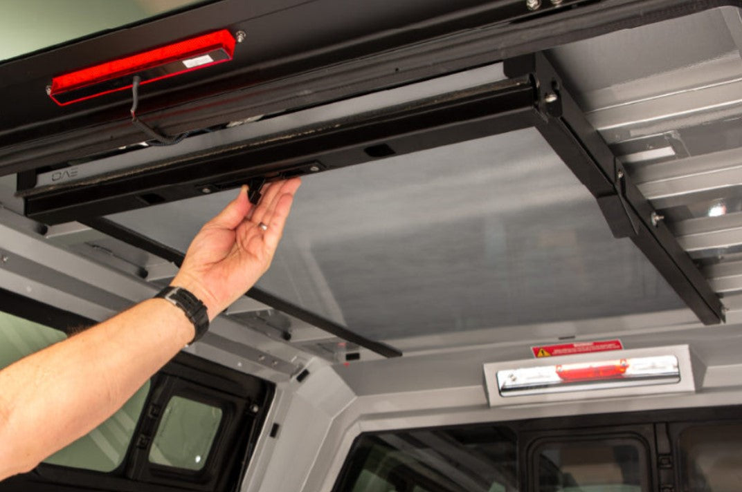 inside a Canopy Hardtop with an arm pushing a latch