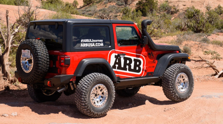 Red JL Jeep wrangler in the desert with a big ARB logo