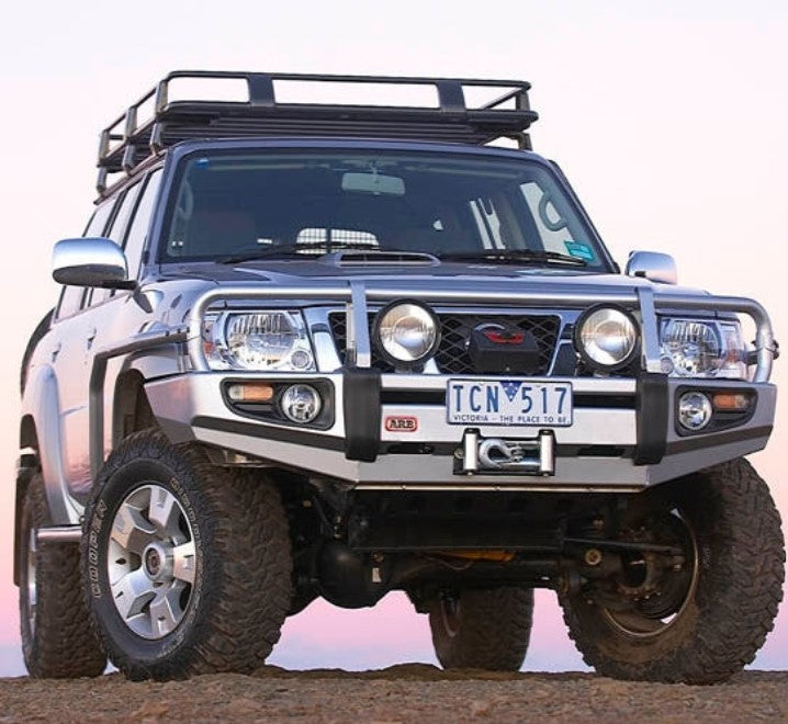 Nissan Patrol Y61 on a rock equipped with a roof rack and bumper