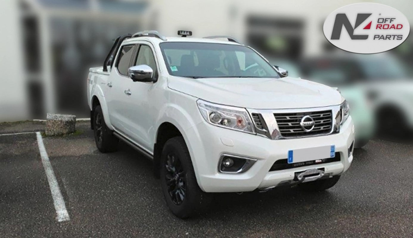 white nissan navara parked in a parking lot
