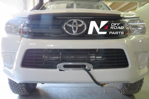 White Toyota front panel with protruding tree trunk