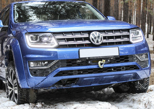 front view of a blue Amarok in snow and forest