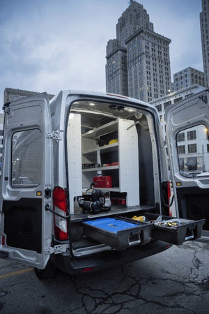 vehicle parked in front of buildings and two open drawers