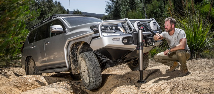 4x4 in a rocky landscape being pulled out by a grey jack