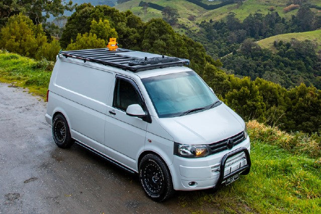 volkswagen transporter in front of a landscape of green hills