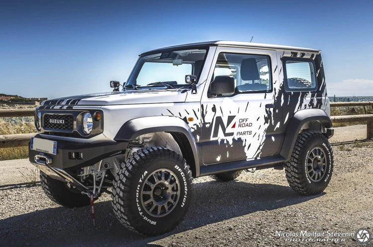 suzuki jimny white and black presented on a track