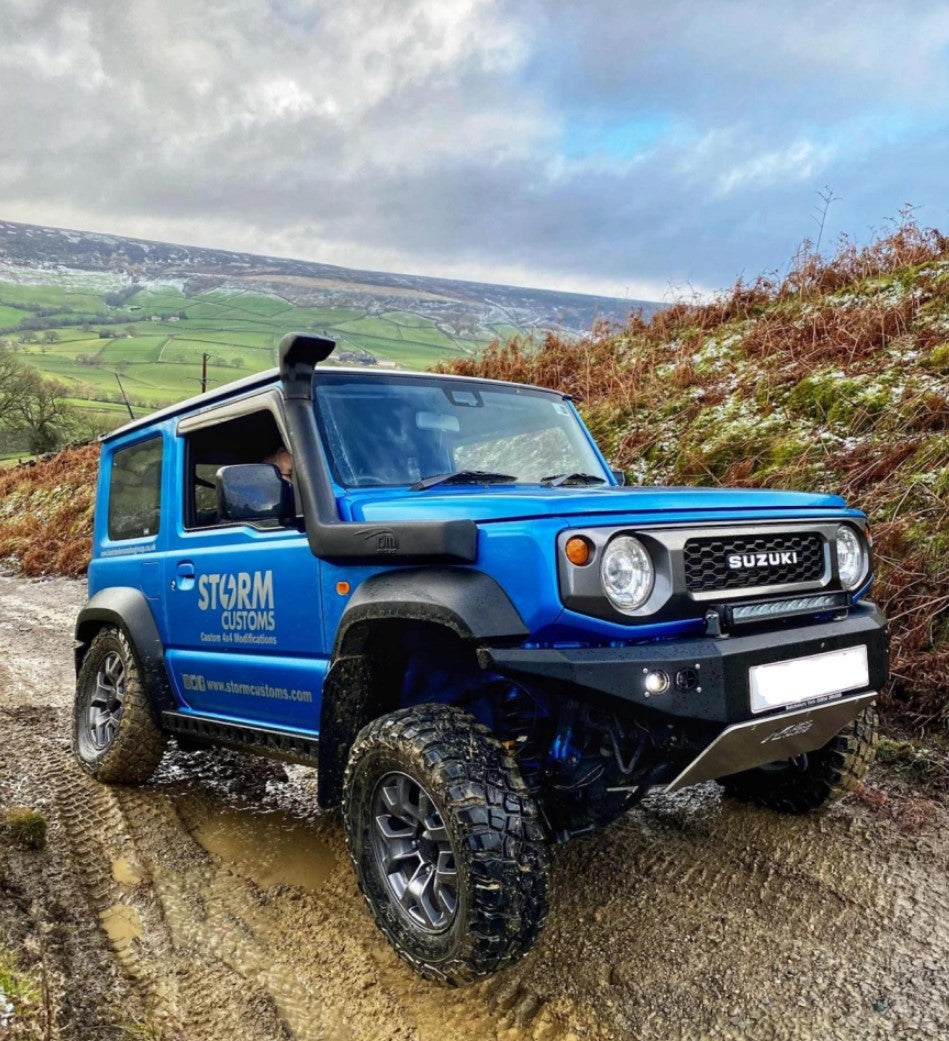 Suzuki Jimny blue in mud with bumper and skid plate
