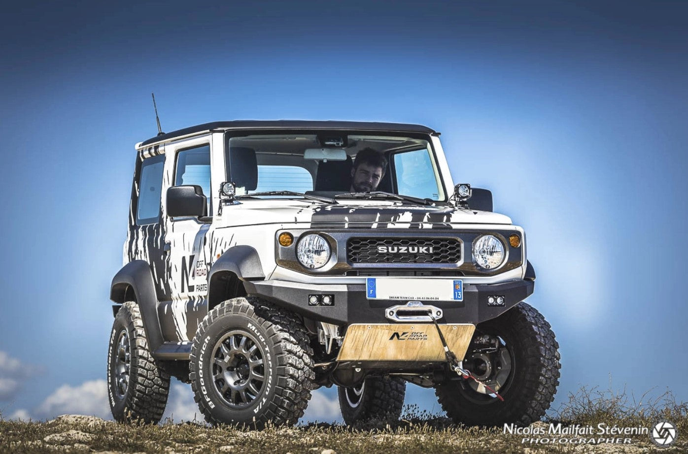 front view of a suzuki jimny with aluminum guard and blue sky