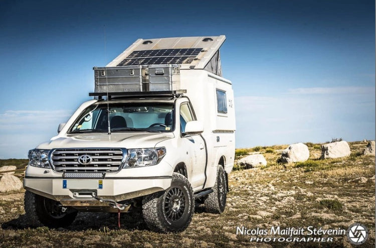 white toyota land cruiser parked on grass with reinforced bumper