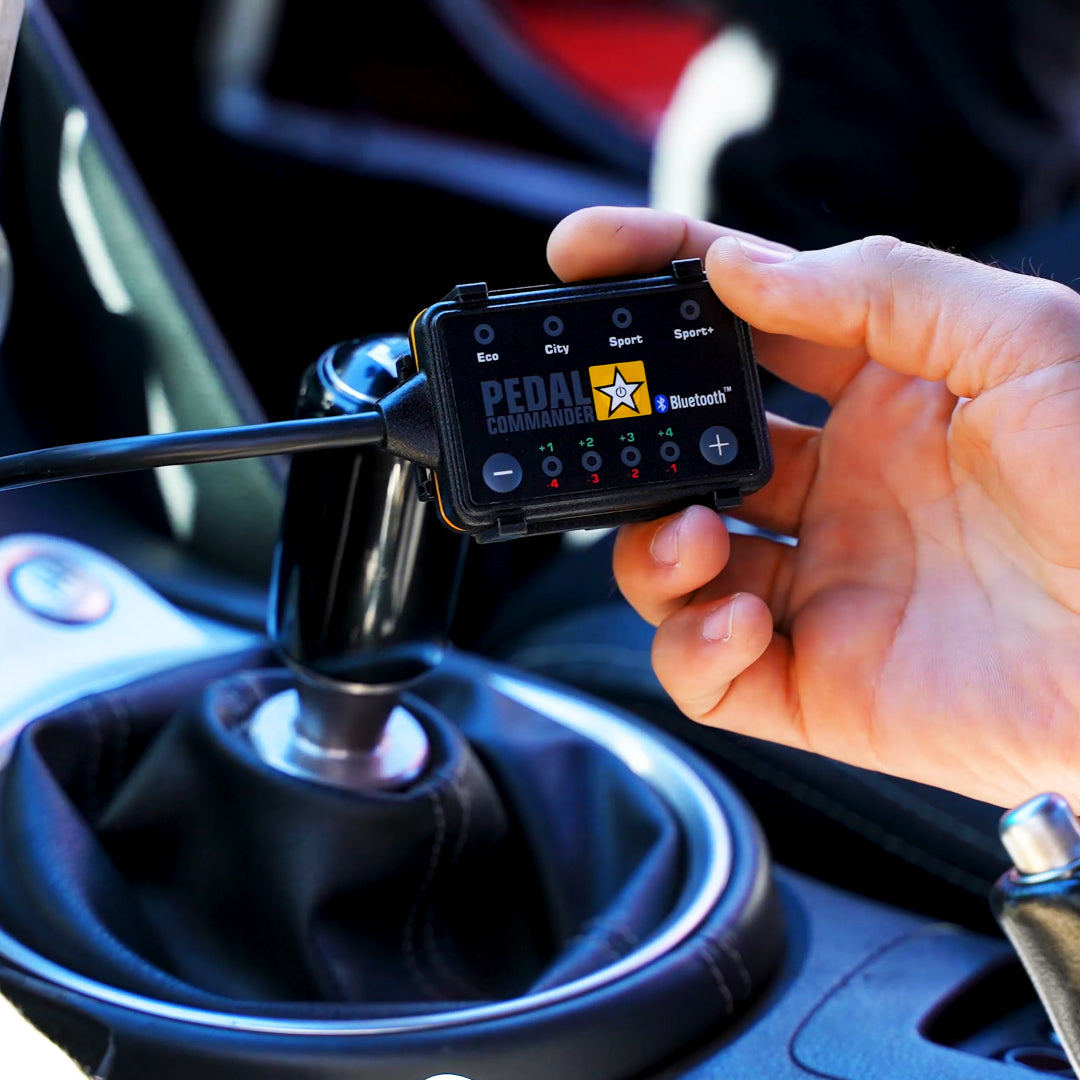 hand holding the pedal control unit in a car