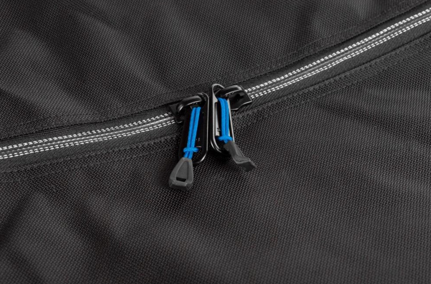 zip fastening with blue cord on black fabric
