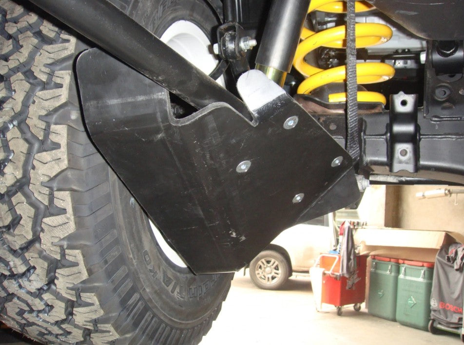 underside of a vehicle with a yellow spring and shock absorber protection
