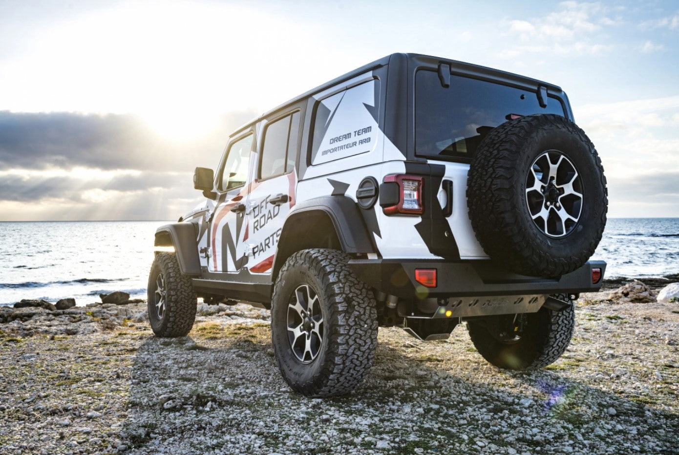 Jeep wrangler JL parked on the rock in front of the sea