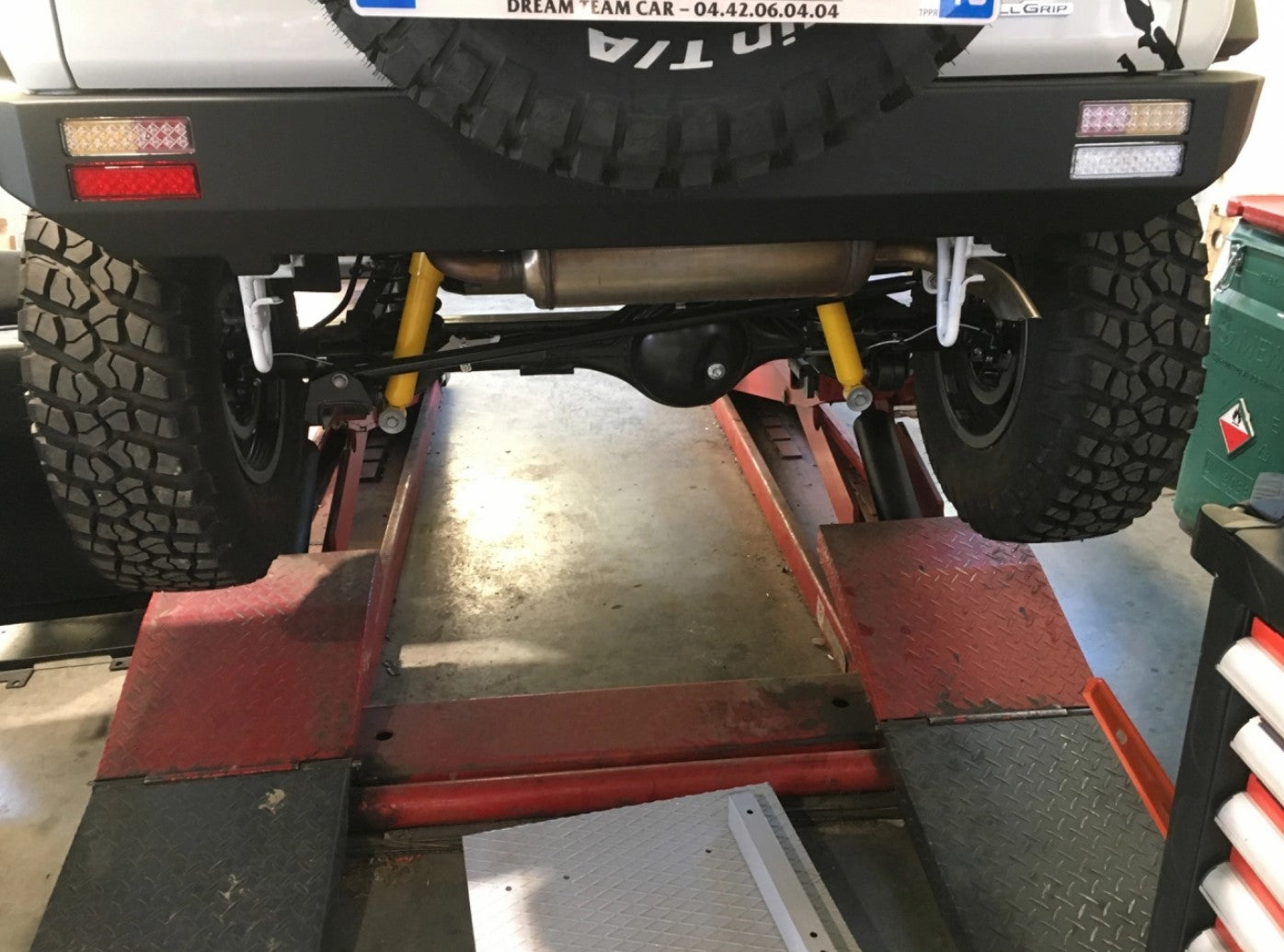 vehicle on a garage deck with yellow shock absorbers