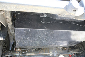 Black tank fixed under a vehicle with soil on top