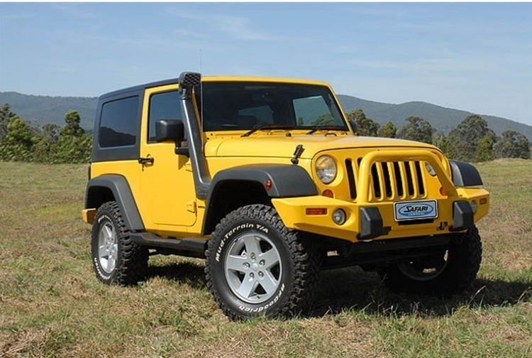 yellow jeep wrangler diesel with a snorkel, in a green landscape