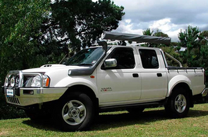 Navara D22 parked in the grass and fitted with a black safari snorkel