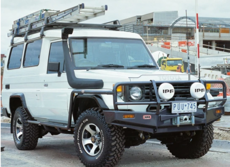 White Land Cruiser 76 with snorkel and ladder on the roof rack