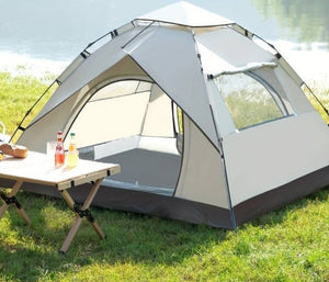 camping tent on the grass in front of the water