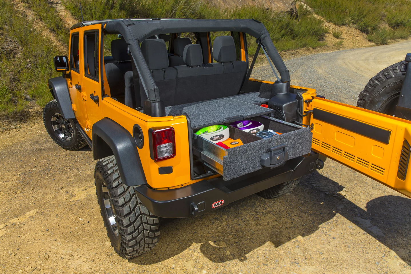 yellow jeep wrangler with open arb drawer in the back of the trunk