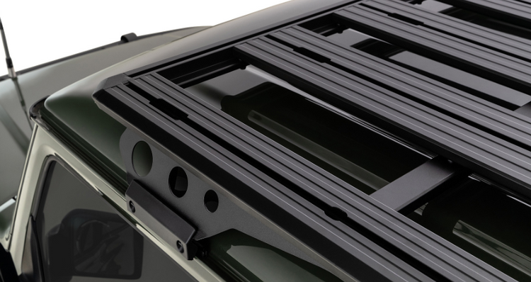 roof rail of a black roof rack on a green vehicle