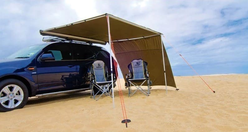 Outdoor bivouac on sand under a brown Awning